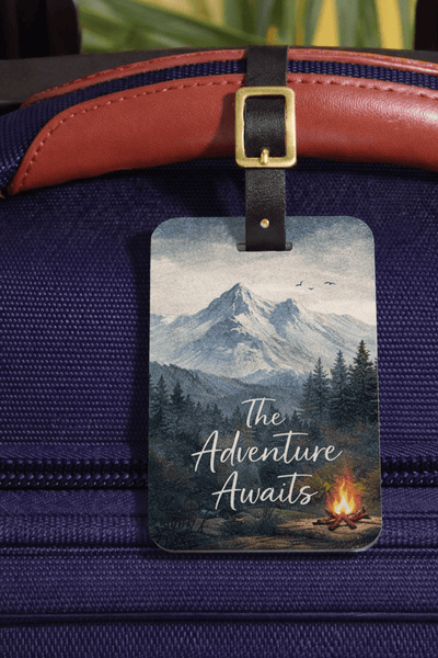 Luggage tag with mountain and campfire design on a blue suitcase